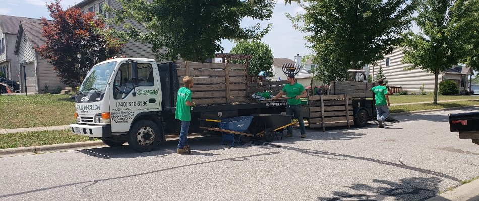 Hoffmans Lawn & Fertilization team unloading equipment from a truck in Delaware, OH