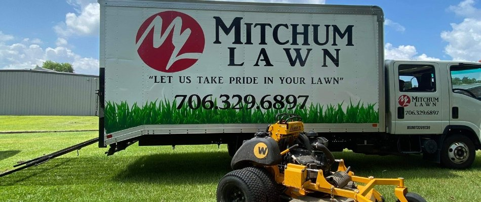 Mitchum Lawn branded truck with a commercial mower in Columbus, GA
