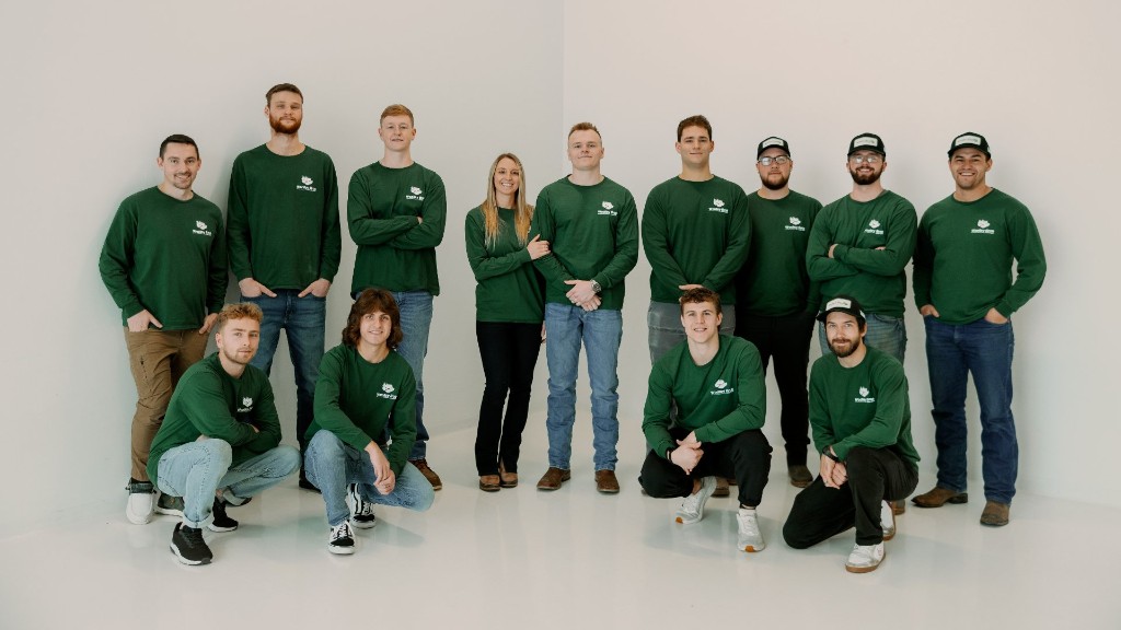 The Woolley Outdoors team in a studio photo wearing branded green long-sleeve shirts in Lititz, PA